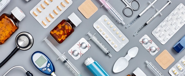 Directly above flat lay flat lay shot of various medical supplies. Full frame shot of medicines placed with syringes and diagnostic tools. All are on gray background. Knolling concept.